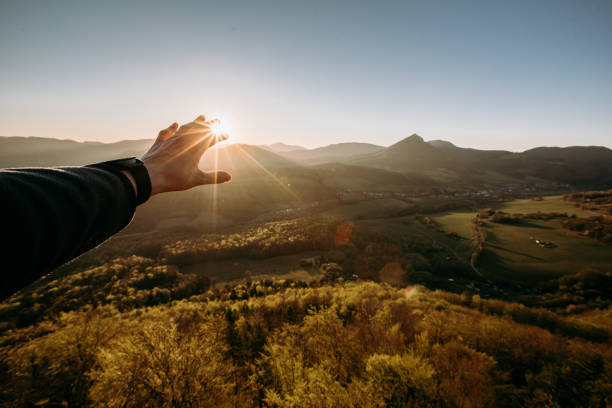 istock touch a sun with hand and morning sky . 1309230973