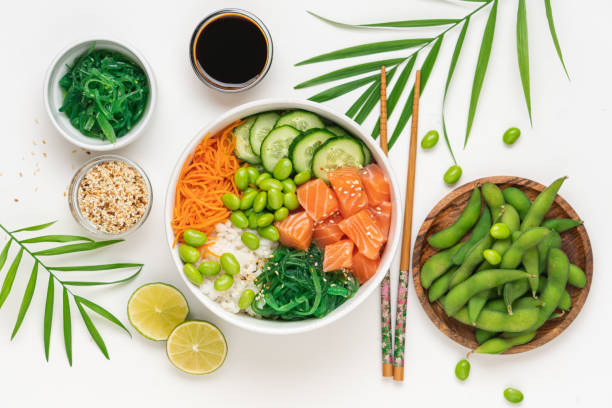Poké bowl with raw salmon Bowl with raw fish, rice, chukka salad, edamame beans, carrots and cucumber. Bowl of healthy food on white background marinated photos stock pictures, royalty-free photos & images
