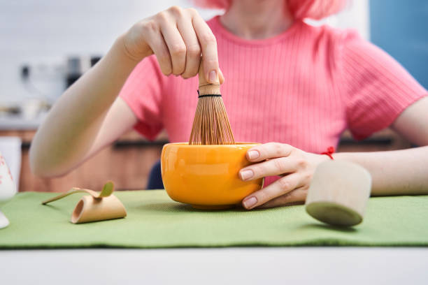 Woman holding modern whisk for whipping the matcha powder at home