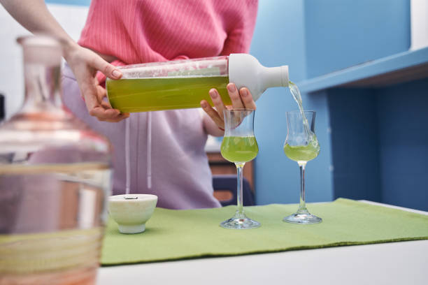 Woman wearing pink clothes pouring matcha drink to the glasses