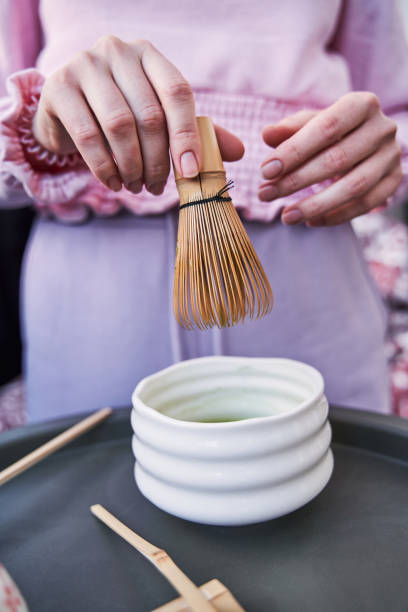 Woman preparing matcha tea at table at the balcony