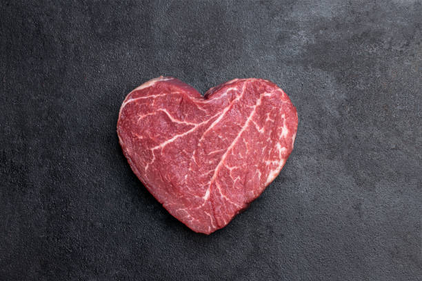 bistecca di manzo fresca cruda a forma di cuore su sfondo metallico - meat raw beef love foto e immagini stock