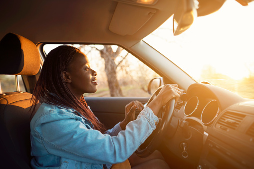 Young African woman driving a car.