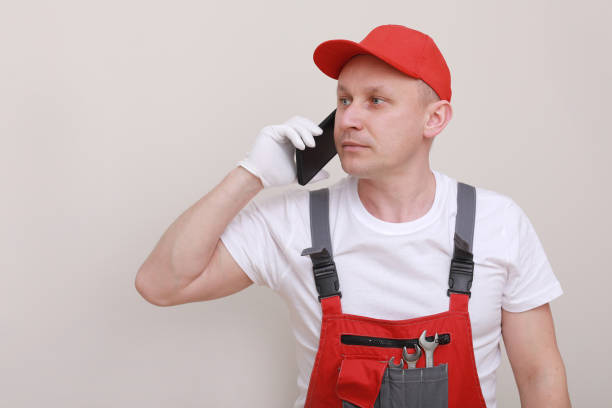 istock construction male worker In red working form and cap with cellphone in hand and communicates with customers isolated on white background. of the service delivery is a career 1309235967