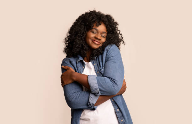 istock Joyful black lady in love hugging herself 1309238696