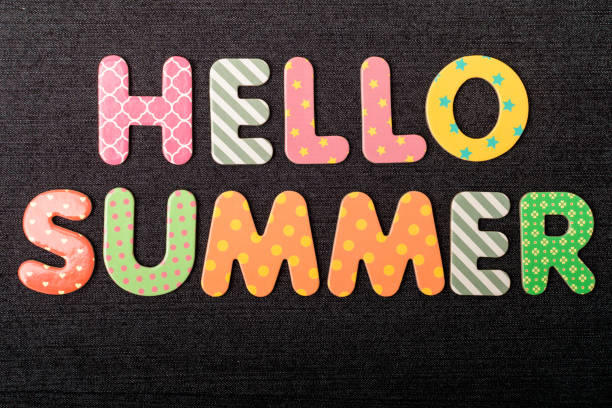 istock Card with Hello Summer words made from mixed vivid colored wooden letters on a textured dark black textile material that can be used as a message 1309238749