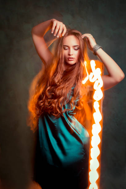 istock Glamorous young woman dancing in mixed light at studio 1309239588
