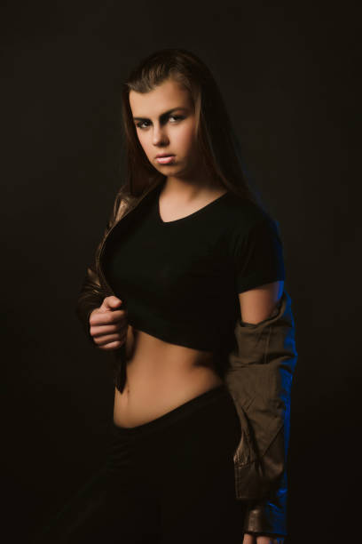 istock Young stylish woman posing at studio in black outfit 1309239594