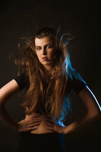 istock Young woman with fluttering hair with wind posing at studio 1309239608