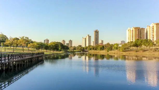 Late afternoon in the ecological park of Indaiatuba with lake reflecting the trees and buildings.