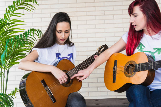 гитаристки-женщины смотрят друг на друга - gay pride flag audio стоковые фото и изображения