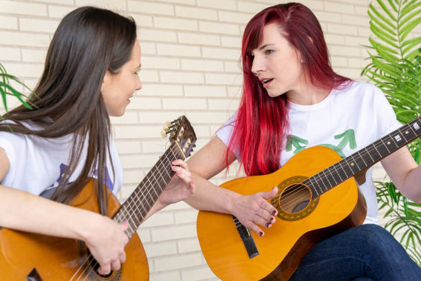 female guitarists looking at each other - parade band imagens e fotografias de stock