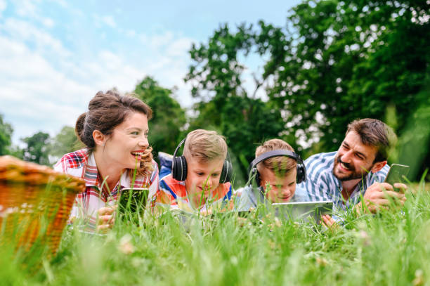 istock Family using mobile phones together in nature. 1309240908