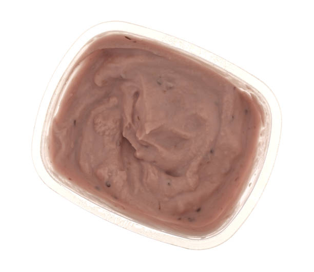 istock Small container of red raspberry yogurt on a white background top view 1309240946