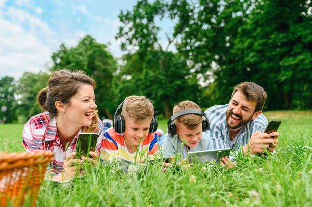 istock Family using mobile phones together in nature. 1309242248