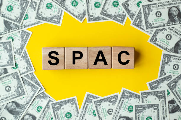 spac, special purpose acquisition company symbol. wooden cubes with word 'spac' on beautiful background from dollar bills, copy space. business and spac, special purpose acquisition company concept. - stock market data insurance savings finance imagens e fotografias de stock