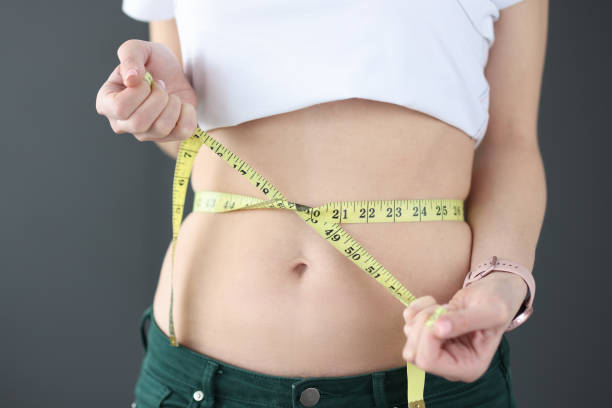 istock Woman measures her waist with centimeter closeup 1309244146