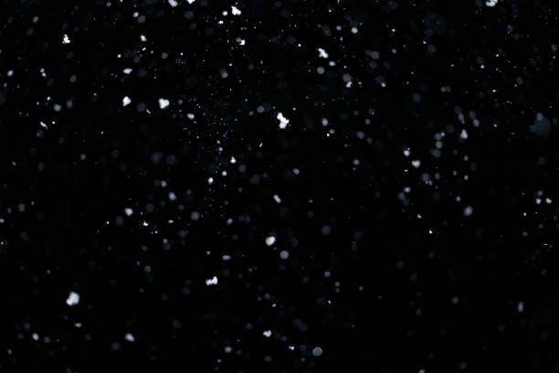 istock Real falling snow on black background for blending modes in ps. Ver 10- few snowflakes in blur 1309244172