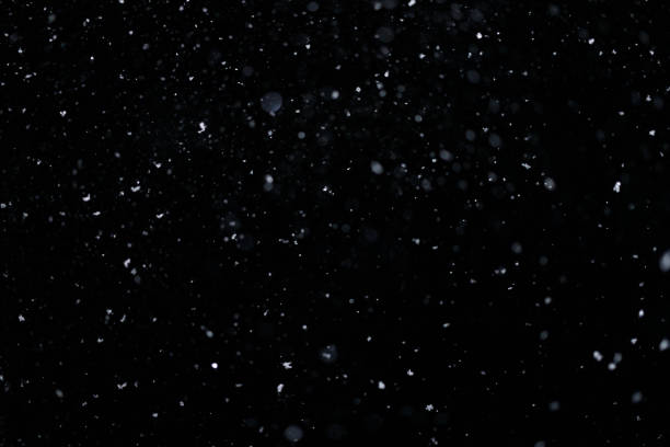 istock Real falling snow on black background for blending modes in ps. Ver 08 - few snowflakes in blur 1309244174