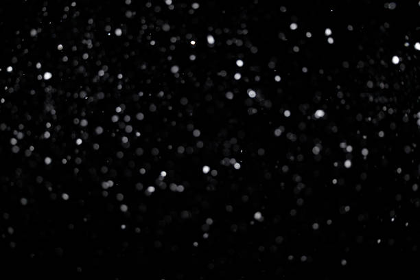 istock Real falling medium sized snowflakes out of focus on black background for overlay blending mode 1309244178