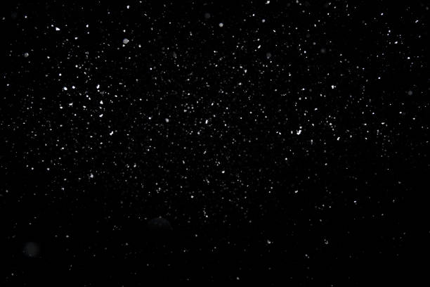 istock Real snowfall out of focus on black background for overlay blending mode 1309244188