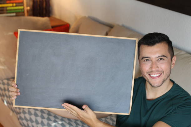 Young man showing blackboard with space for editing.