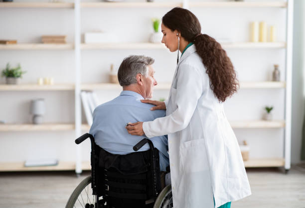 istock Elderly patient with physical disability receiving medical help from young physician during covid epidemic 1309245882
