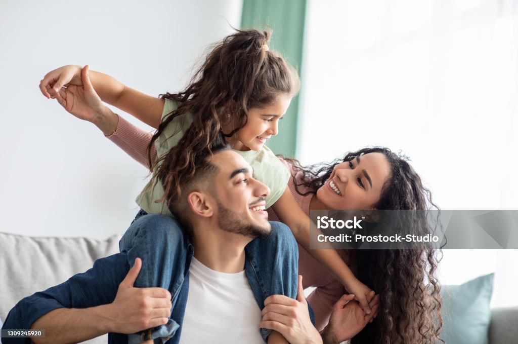 Fröhliche nahöstliche Familie von drei haben Spaß zusammen zu Hause - Lizenzfrei Familie Stock-Foto