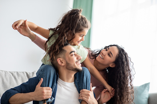 Alegre familia de Oriente Medio de tres divirtiéndose juntos en casa photo