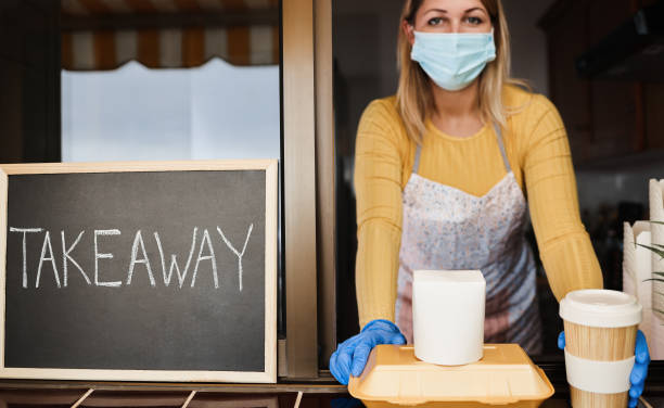 istock Young woman preparing takeaway food inside restaurant during coronavirus outbreak - Focus on meal 1309245946