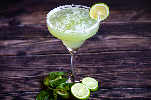 Margarita with lime wedges and salted glass