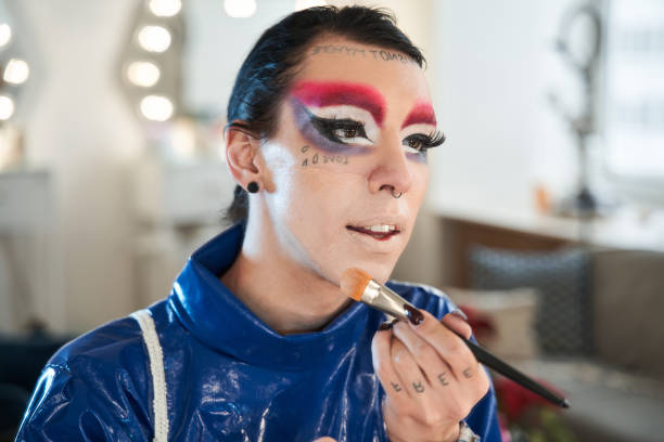 istock Drag queen with false eyelashes and septum at his nose looking at the mirror 1309247041