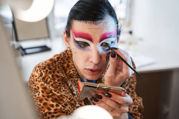istock Drag queen holding hand mirror and applying eyeshadow at his face 1309247042