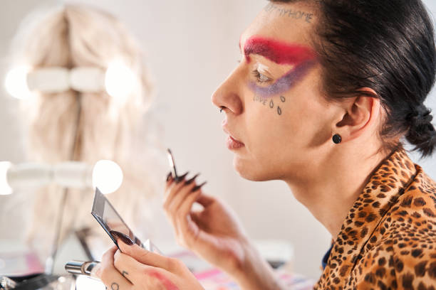 istock Drag queen with long nails looking at his reflection at the mirror 1309247059
