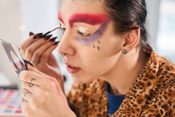 istock Drag queen with long nails applying eye shadows at his eyelids 1309247061