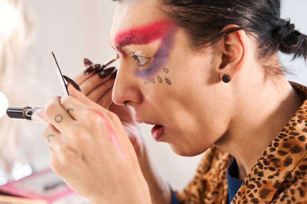 istock Drag queen with long nails applying eye shadows at his eyelids 1309247065