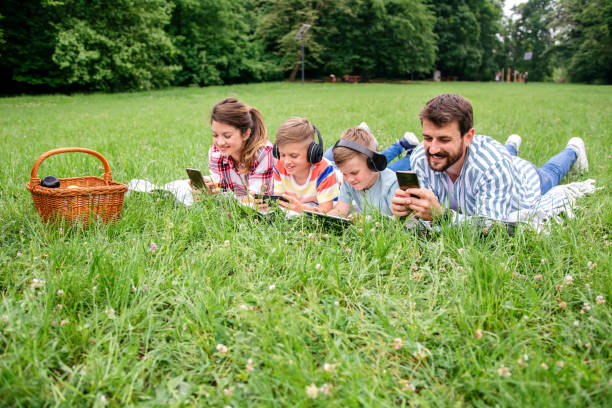istock Family using mobile phones together in nature. 1309247421