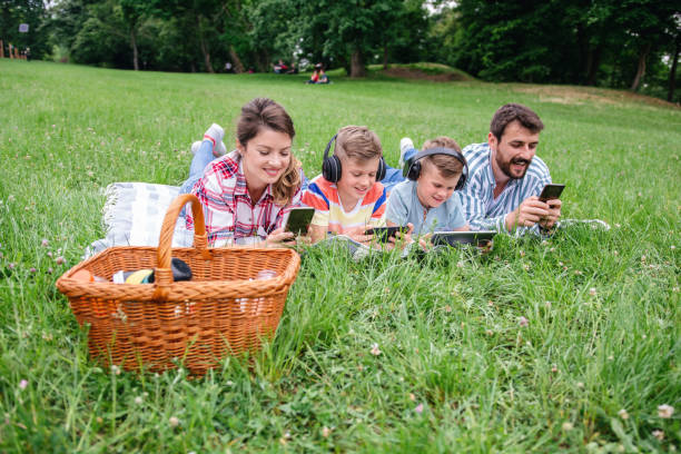 istock Family using mobile phones together in nature. 1309247431