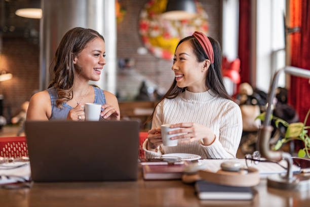 istock Two smiling woman having a coffee break at work 1309248734