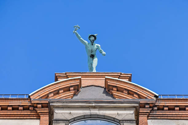 statue von hermes auf dem dach eines hohen gebäudes - denmark copenhagen brick street stock-fotos und bilder