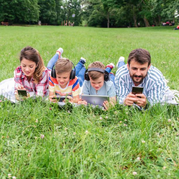 istock Family using mobile phones together in nature. 1309249284