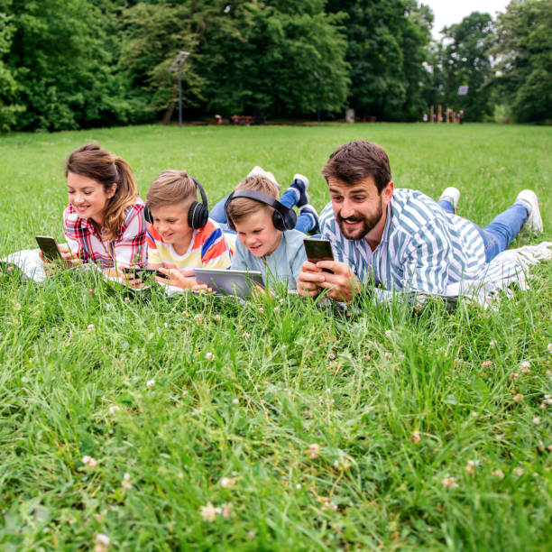 istock Family using mobile phones together in nature. 1309249287