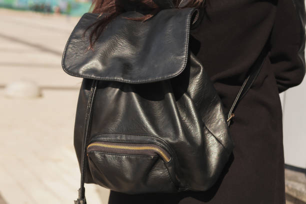 istock Stylish dressed woman tourist posing witn a black leather backpack 1309249446