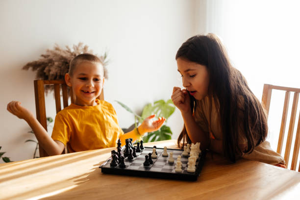 istock Cute Kids Playing Chess At Home 1309252341