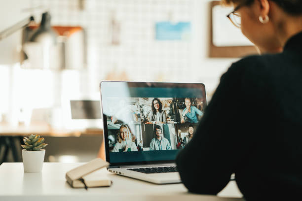 istock Woman has video call with her team using laptop and camera 1309252700