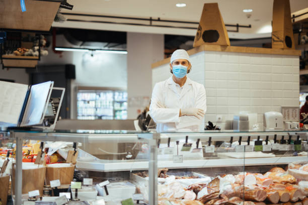 istock Manager of a delicatessen with protective face mask on facing camera smiling 1309253264