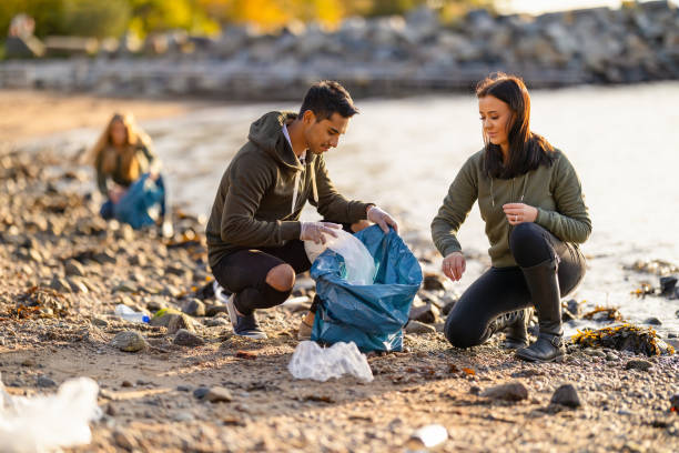 istock Team of hard working volunteers collecting plastic garbage at beach 1309254517