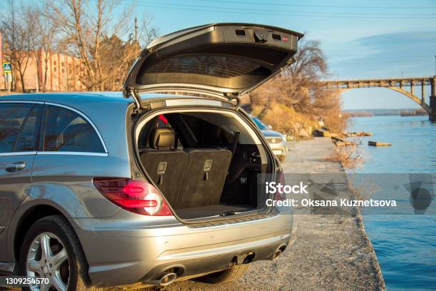 Car Mercedesbenz R 350 With An Open Trunk On The Embankment Against The Backdrop Of The City Skyline At Sunset Stock Photo - Download Image Now