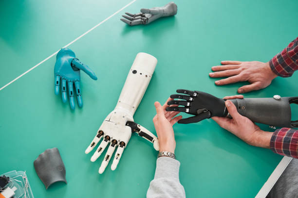 istock Young people holding prototype of mechanical hand in laboratory 1309255589