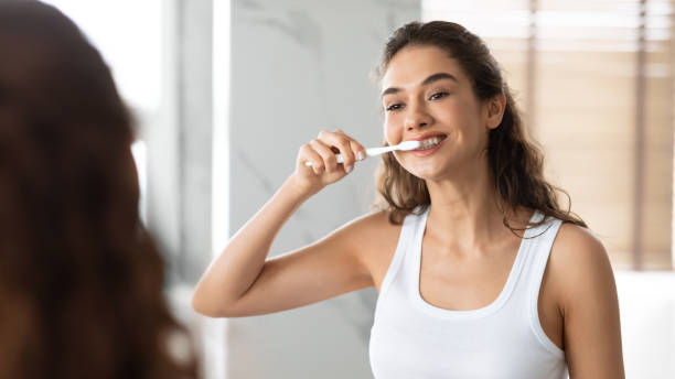 istock Happy Lady Brushing Teeth With Toothbrush Standing In Bathroom Indoor 1309256303